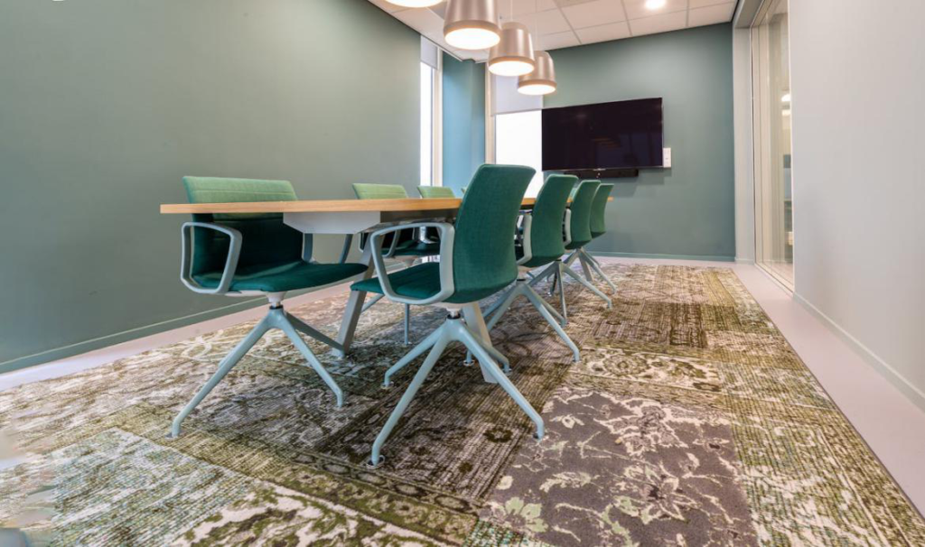 An image of an office conference room with green walls and green chairs