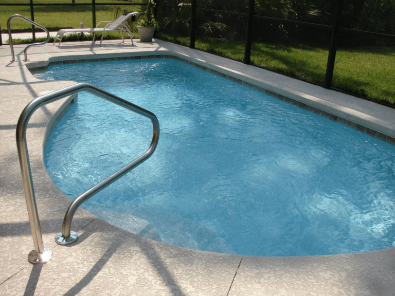 An image of a clear swimming pool with a concrete pool deck
