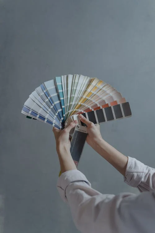A person holding paint shades