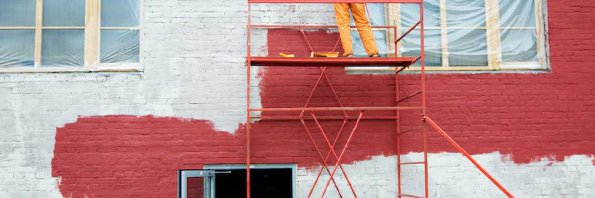 A painter painting the exterior of a building
