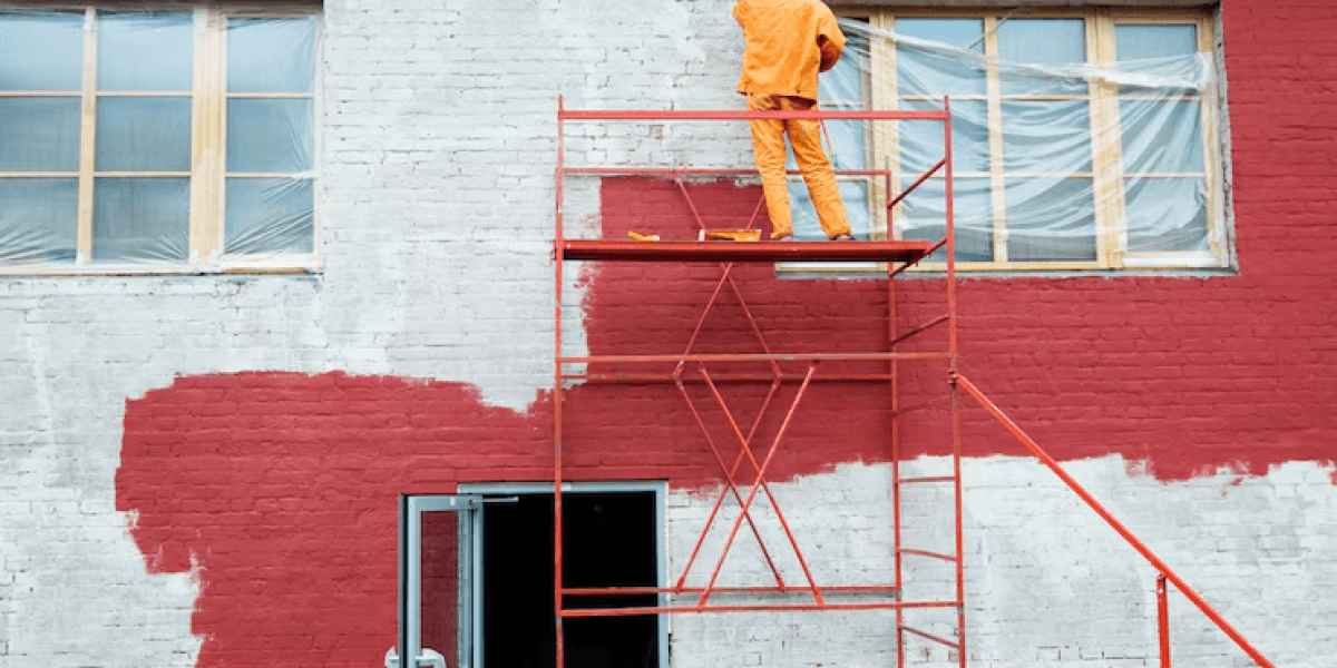 A painter painting the exterior of a building